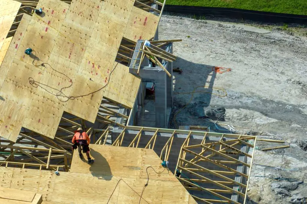professional-builders-working-on-roof-construction-2024-12-06-01-42-37-utc alt="professional roof replacement decking in spring with large home"