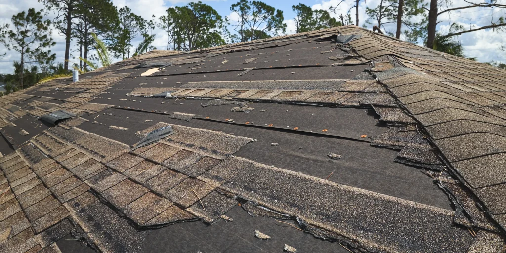 alt="shingls missing on roof after storm damage"