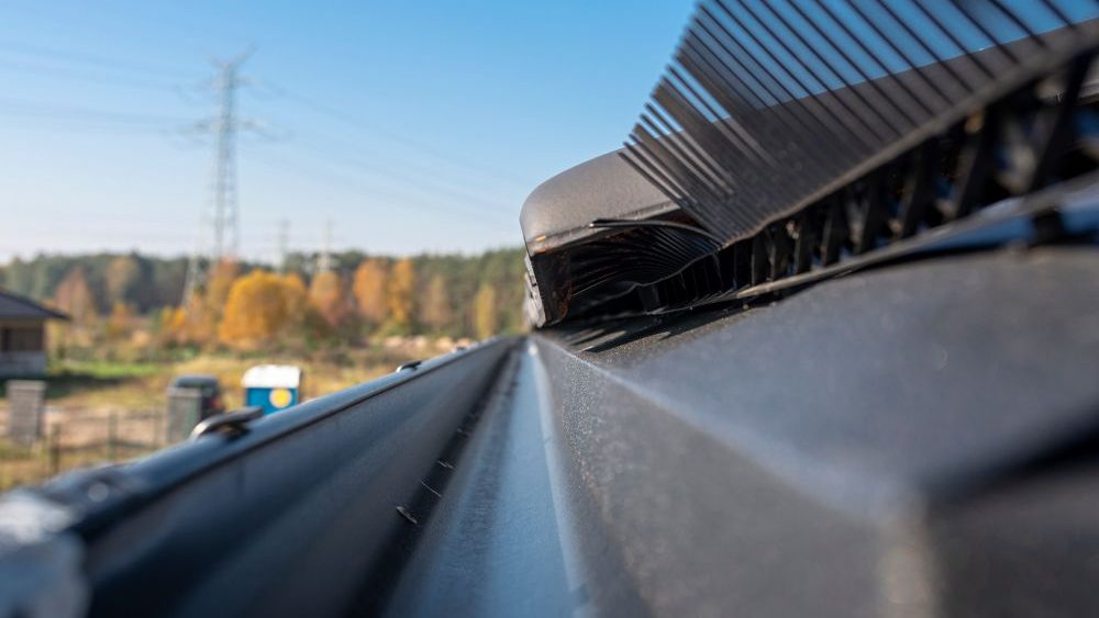 a-metal-black-gutter-on-a-roof-covered-with-ceram-2025-03-12-20-54-26-utc