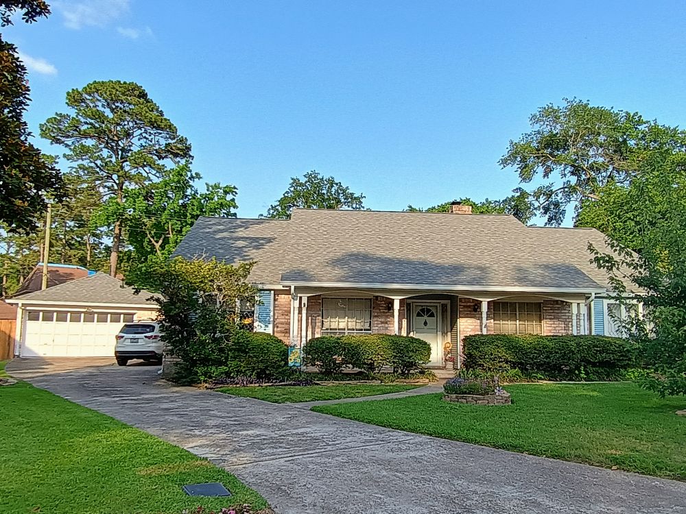 northamericanroofingcompleteroofreplacementinspringsmallhouse alt="hurricane season in spring, tx house prepared for storm, small house with pillars and green grass"