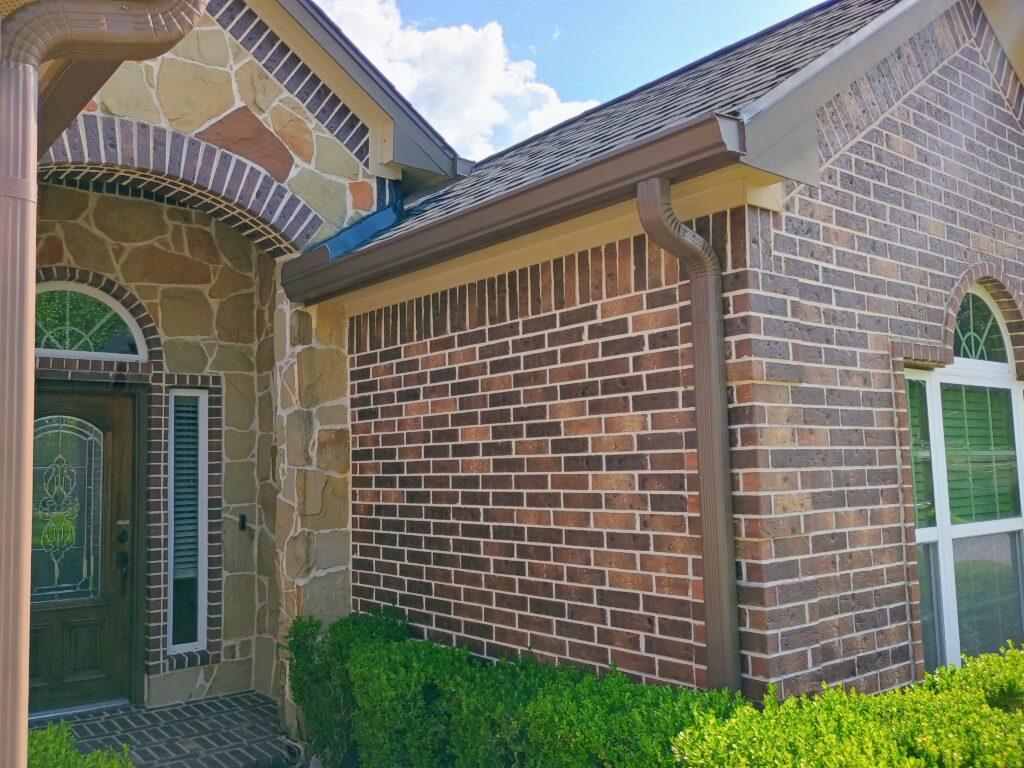Oversized downspout installation for improved water runoff on a Tomball residence.