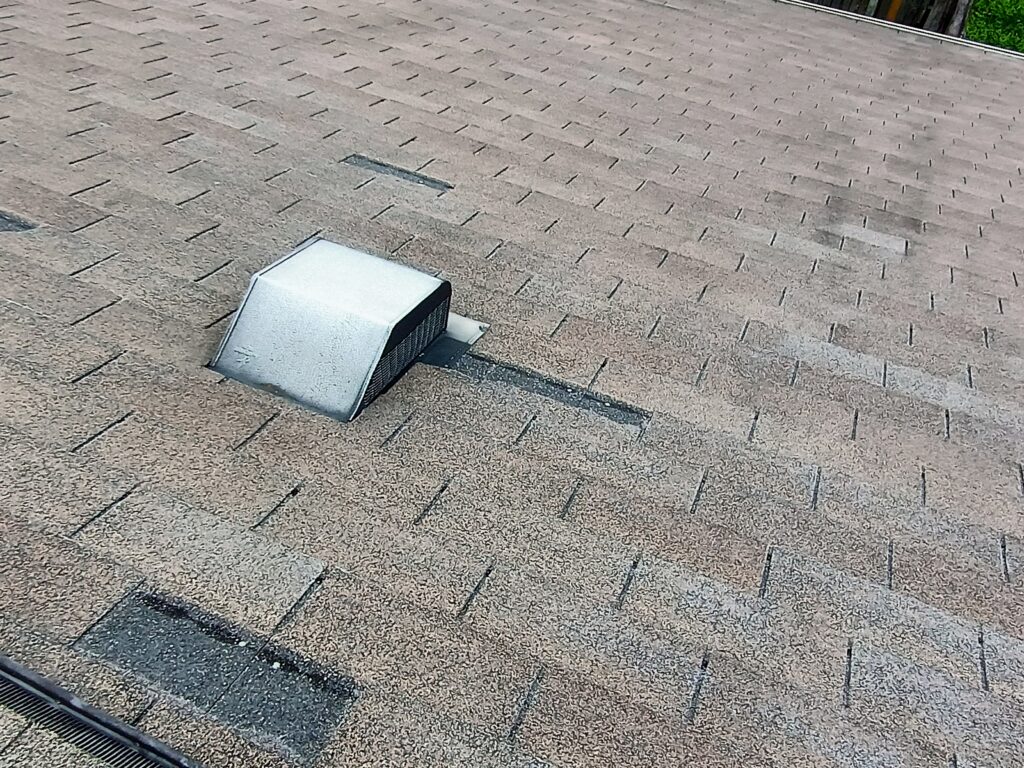 Contractor repairing wind-damaged roof section in Tomball TX.