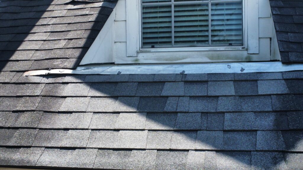 Close-up inspection of chimney flashing and pipe boots to prevent leaks in a Klein home.