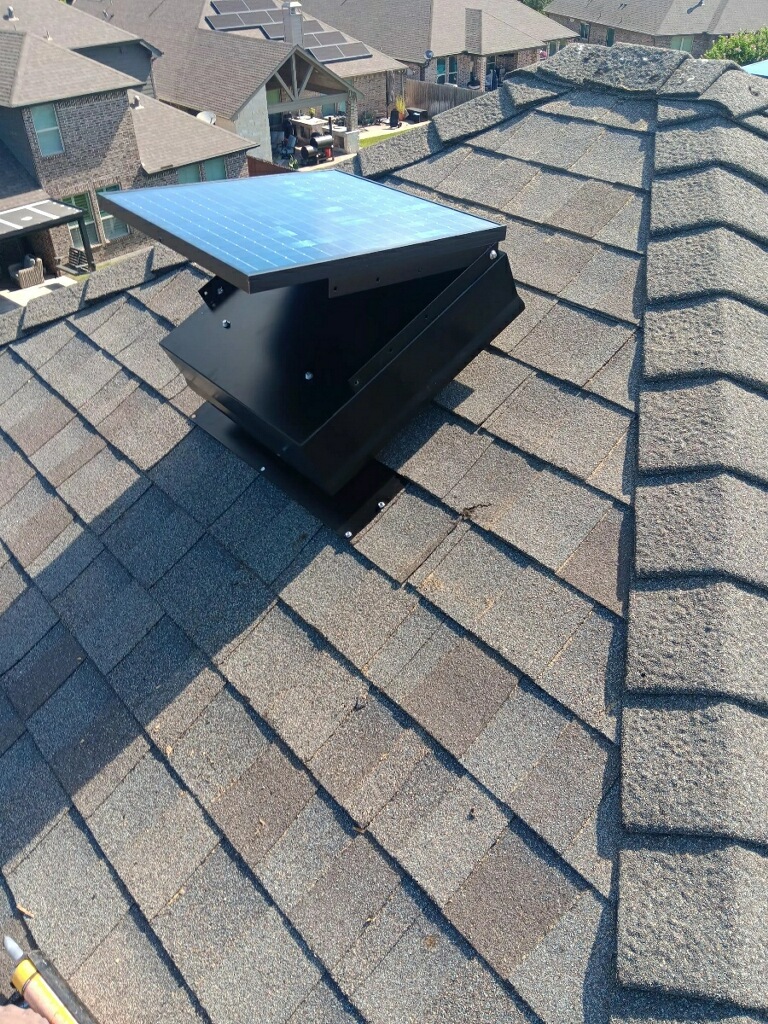 North American Roofing contractor securing a solar attic vent to a waterproof flashing.