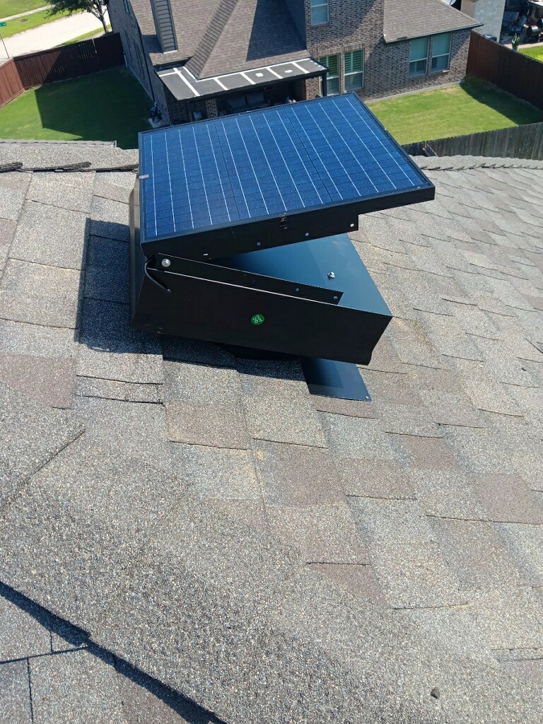 Multiple solar attic vents properly spaced on a large residential roof in Tomball.